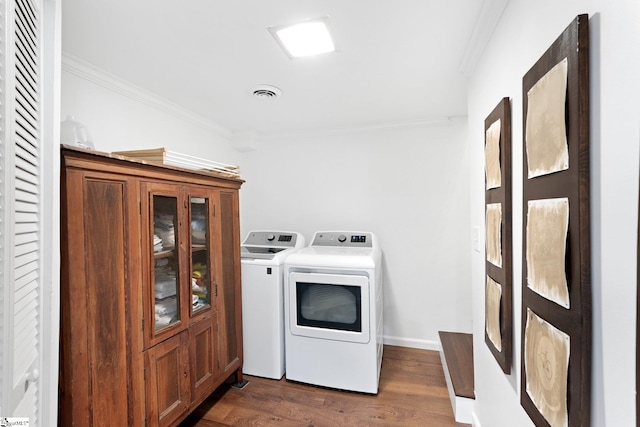 washroom featuring ornamental molding, dark hardwood / wood-style flooring, and independent washer and dryer