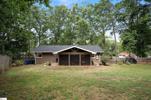 rear view of house with a yard and a sunroom