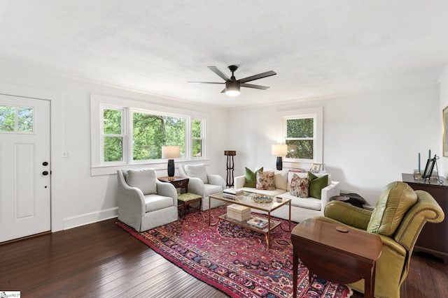 living room with ceiling fan, plenty of natural light, dark hardwood / wood-style flooring, and crown molding