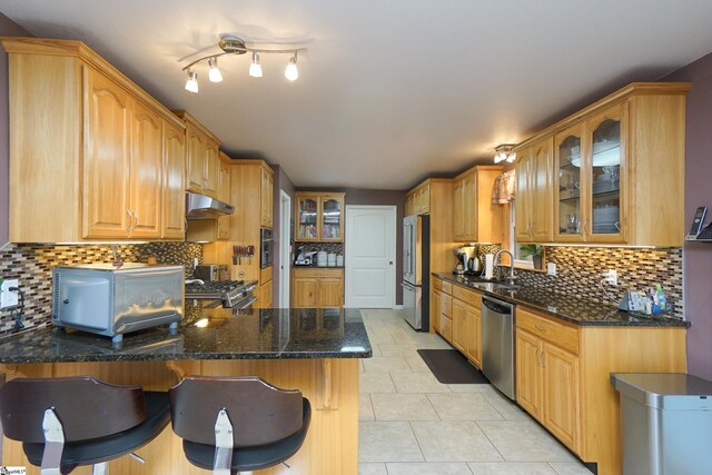 kitchen featuring tasteful backsplash, appliances with stainless steel finishes, sink, kitchen peninsula, and light tile patterned floors