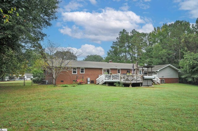 rear view of property with central AC, a wooden deck, and a lawn