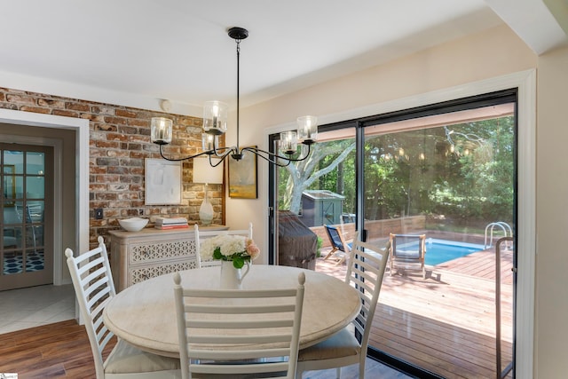 dining space with hardwood / wood-style flooring and an inviting chandelier