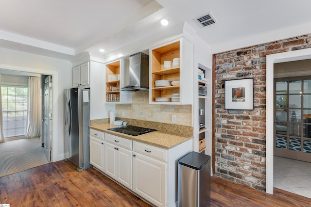 kitchen with wall chimney exhaust hood, stainless steel refrigerator, white cabinets, and dark hardwood / wood-style flooring