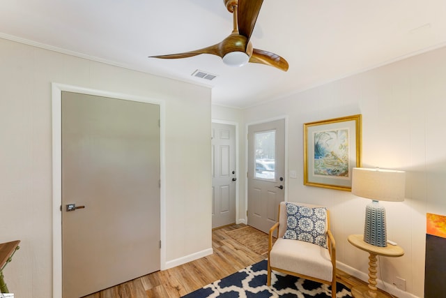 sitting room with light wood-type flooring and ornamental molding