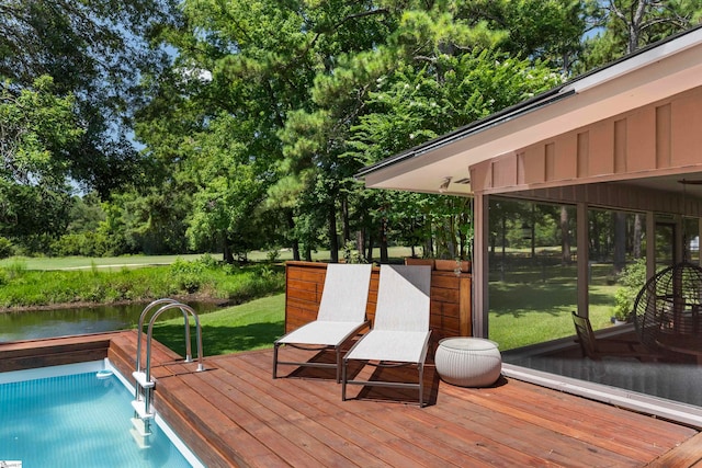 view of pool with a lawn and a deck with water view