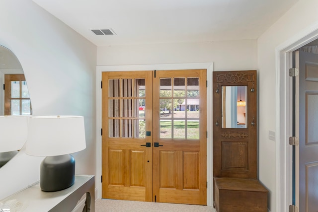 entryway featuring french doors and light colored carpet