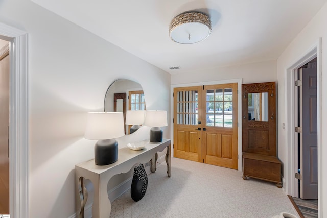 carpeted foyer featuring french doors