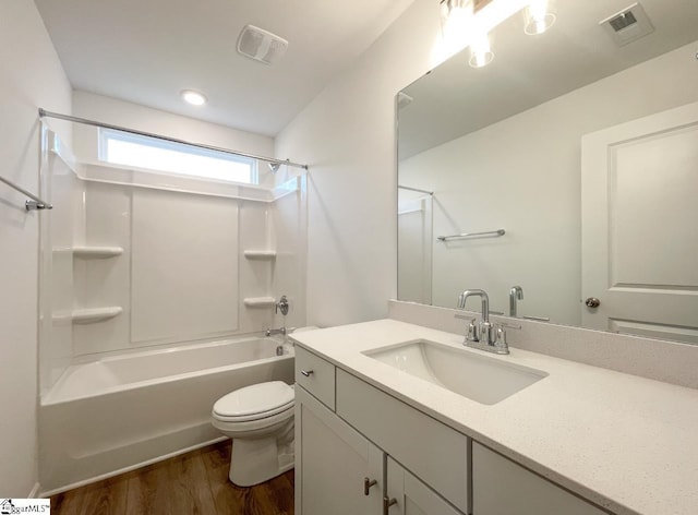 full bathroom featuring shower / washtub combination, hardwood / wood-style floors, vanity, and toilet