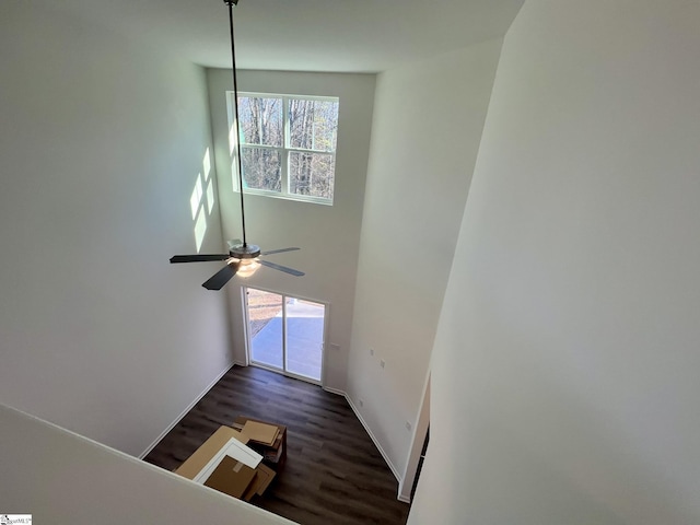 interior space featuring ceiling fan, a high ceiling, and hardwood / wood-style flooring