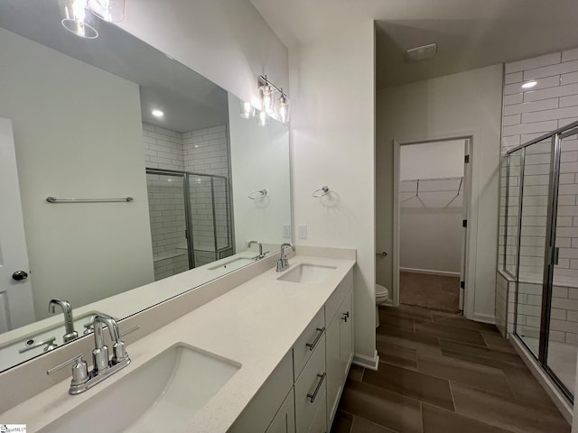 bathroom featuring vanity, toilet, and a shower with door