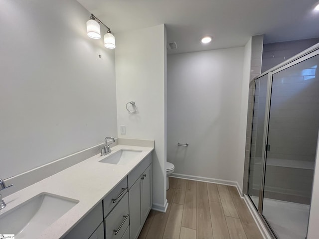 bathroom featuring a shower with shower door, wood-type flooring, toilet, and vanity