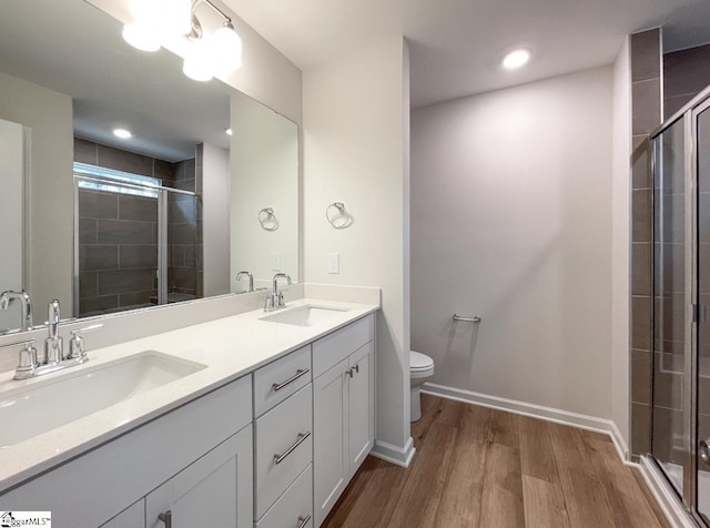 bathroom featuring vanity, hardwood / wood-style floors, toilet, and walk in shower