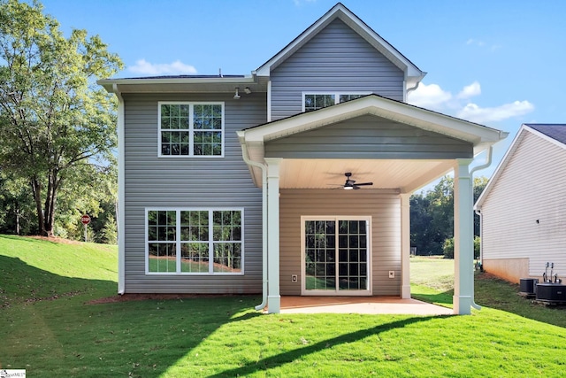 rear view of house with ceiling fan, a yard, and a patio area