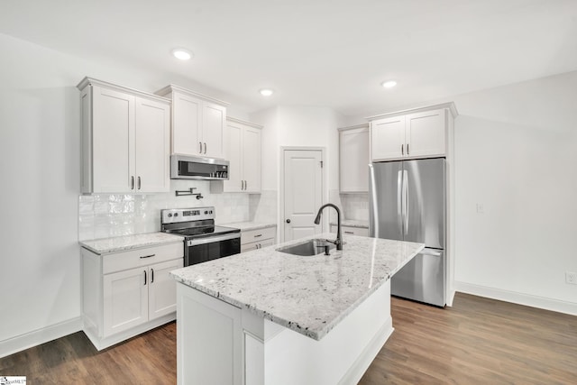 kitchen featuring light stone counters, an island with sink, sink, stainless steel appliances, and dark hardwood / wood-style flooring