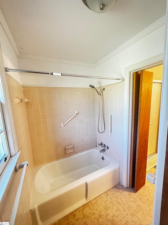 bathroom with crown molding and tiled shower / bath