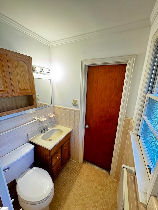 bathroom featuring tile walls, vanity, ornamental molding, and toilet