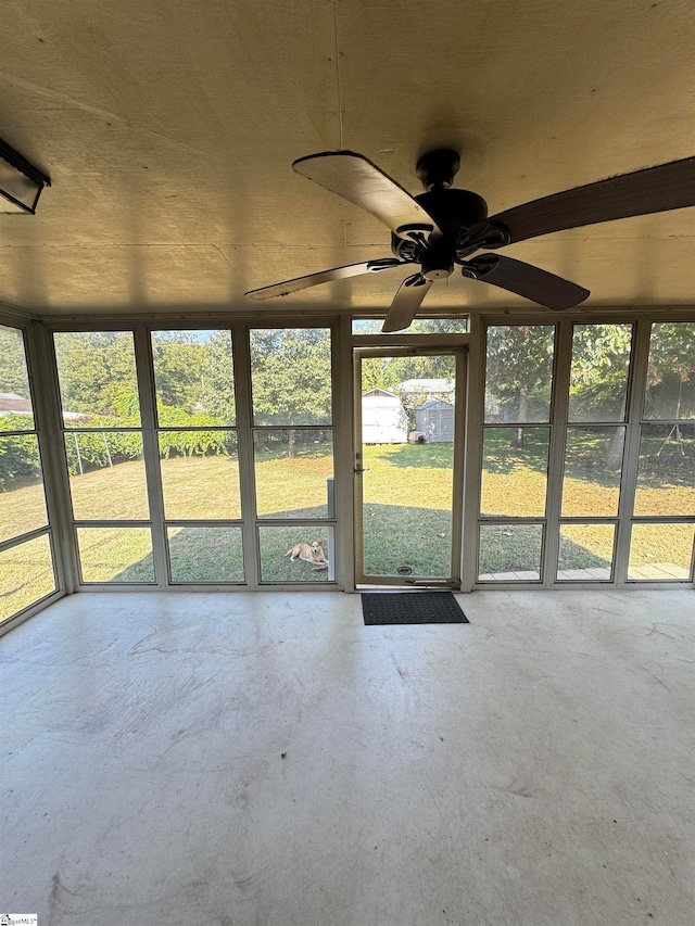 unfurnished sunroom featuring ceiling fan