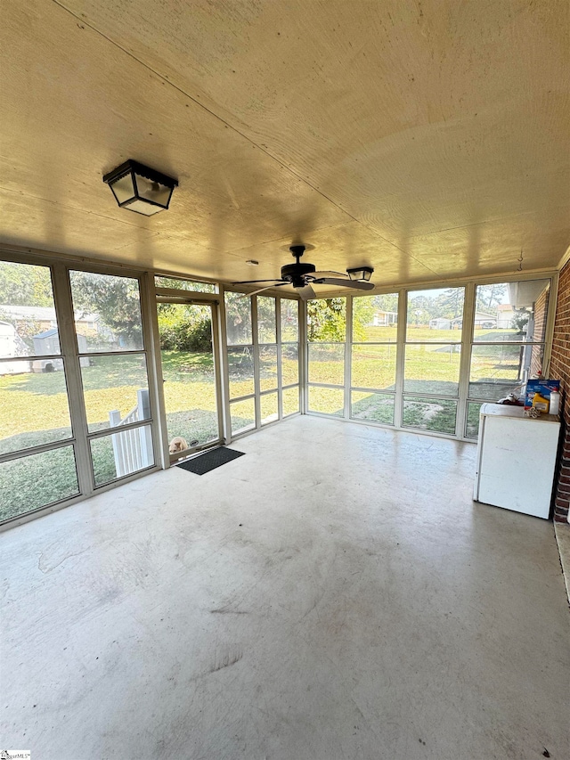 unfurnished sunroom with ceiling fan