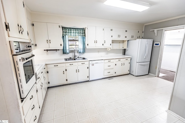 kitchen featuring white appliances, crown molding, white cabinetry, and sink