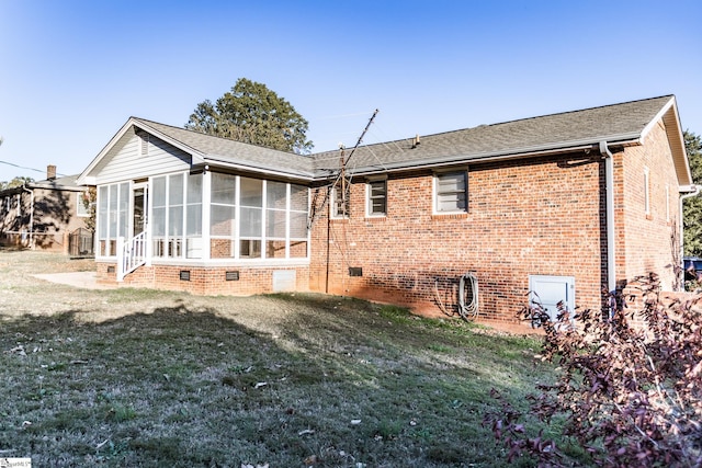 back of property with a sunroom and a lawn