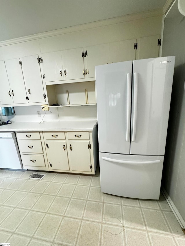 kitchen with white appliances, white cabinetry, and ornamental molding