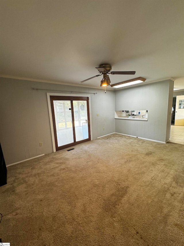 unfurnished living room with ceiling fan, carpet, and ornamental molding