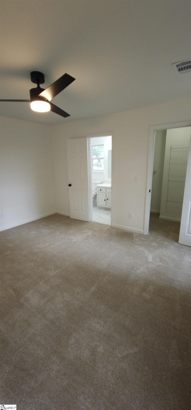 unfurnished bedroom featuring carpet, connected bathroom, and ceiling fan