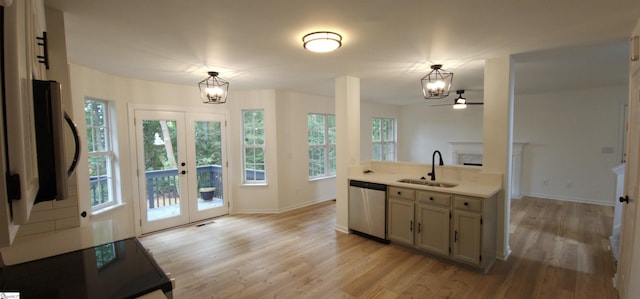 kitchen featuring pendant lighting, sink, an inviting chandelier, light hardwood / wood-style flooring, and stainless steel dishwasher