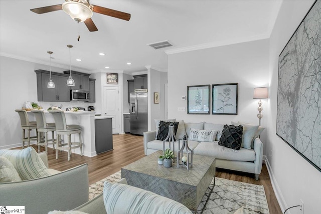 living room featuring ornamental molding, ceiling fan, and dark hardwood / wood-style floors