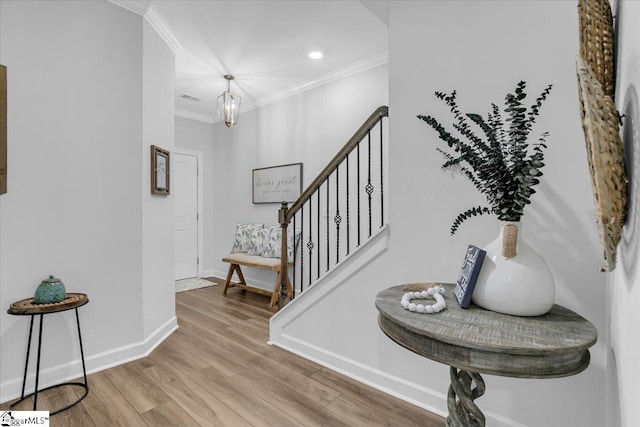 entryway with ornamental molding, an inviting chandelier, and hardwood / wood-style flooring