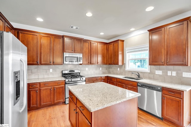 kitchen featuring light stone countertops, appliances with stainless steel finishes, sink, and light hardwood / wood-style flooring