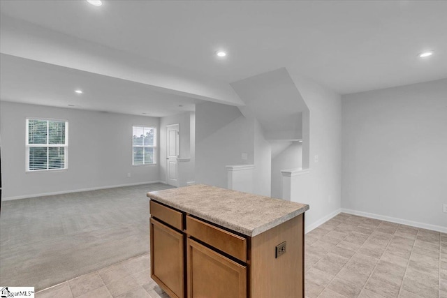 kitchen with light colored carpet and a kitchen island