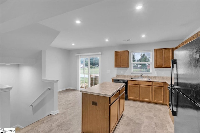 kitchen featuring black appliances, a center island, and sink