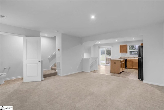 unfurnished living room with light colored carpet