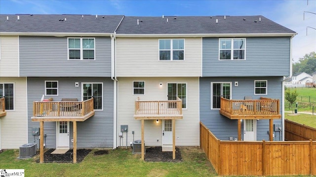 rear view of property featuring a balcony and a yard