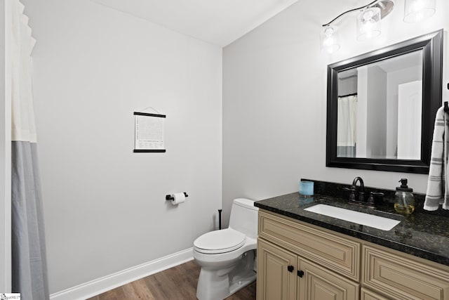 bathroom with wood-type flooring, vanity, and toilet