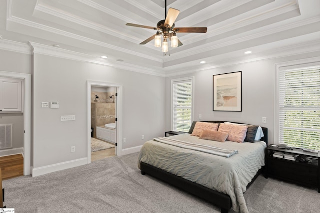 carpeted bedroom with ceiling fan, a raised ceiling, ornamental molding, and multiple windows