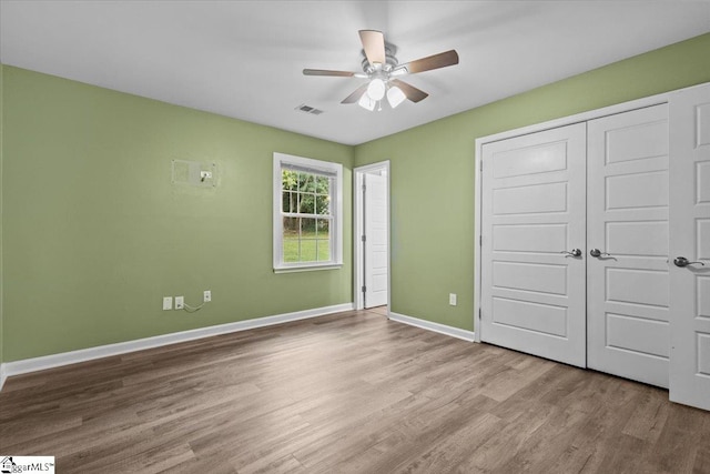 unfurnished bedroom with ceiling fan, a closet, and light hardwood / wood-style floors