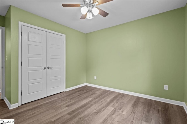 unfurnished bedroom featuring a closet, wood-type flooring, and ceiling fan