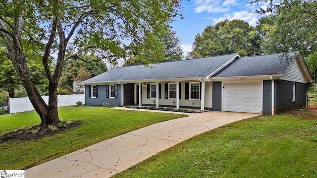 ranch-style house featuring a garage, covered porch, and a front yard