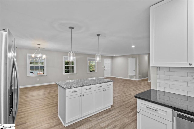 kitchen with backsplash, appliances with stainless steel finishes, light wood-type flooring, and white cabinetry