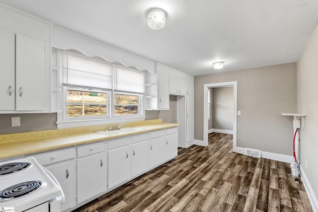 kitchen featuring a sink, white cabinetry, light countertops, white range with electric stovetop, and dark wood finished floors