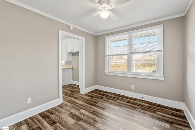 unfurnished room with dark wood-type flooring, ornamental molding, baseboards, and ceiling fan