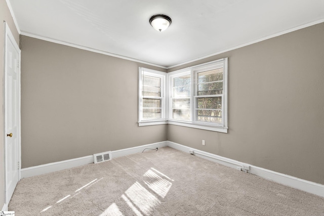 carpeted empty room with ornamental molding, visible vents, and baseboards