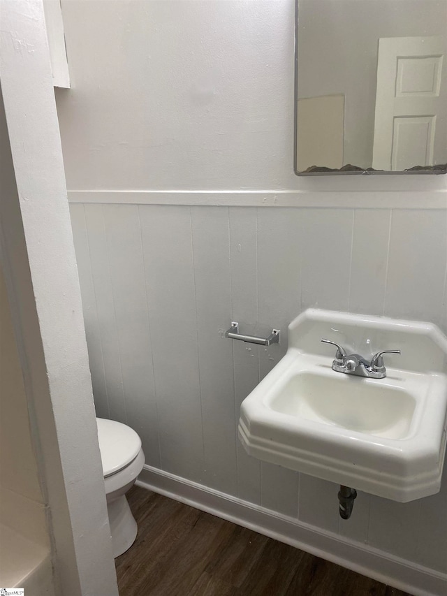 bathroom with wood-type flooring, sink, and toilet