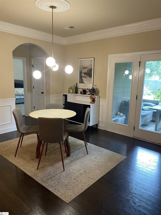 dining area with crown molding and dark wood-type flooring