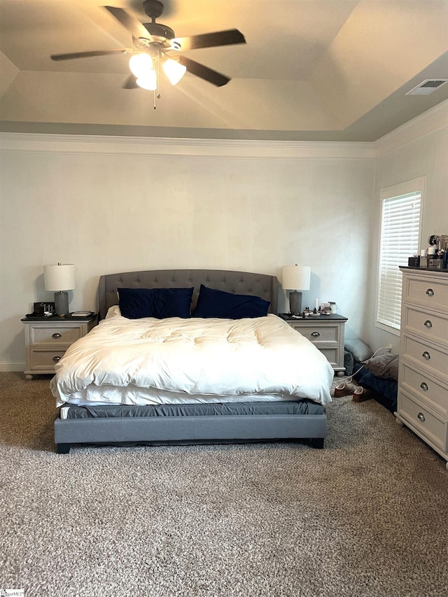 carpeted bedroom featuring ceiling fan, a raised ceiling, and ornamental molding