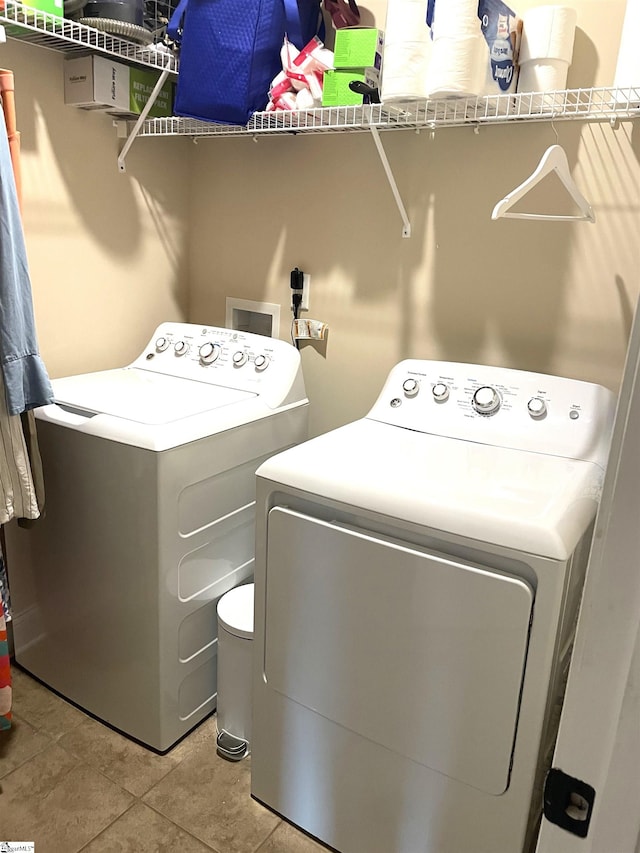 laundry area featuring separate washer and dryer and light tile patterned floors