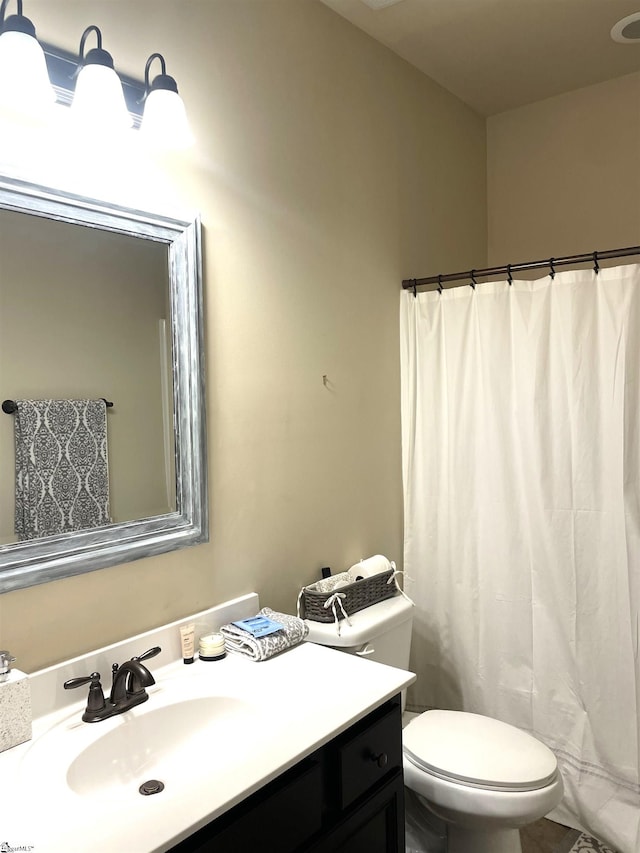 bathroom with vanity, toilet, and curtained shower