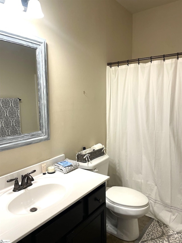 bathroom featuring walk in shower, vanity, toilet, and tile patterned floors